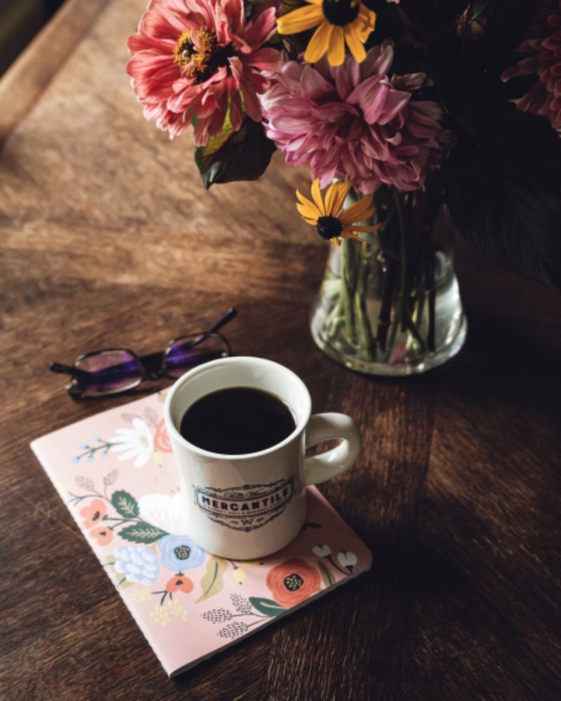 قهوه، گل و میز چوبی